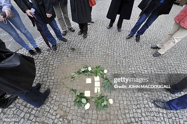 Residents and onlookers stand around recently layed "stolpersteine" or stumbling stones in Berlin's Friedrichstrasse March 27, 2010. The stones,...
