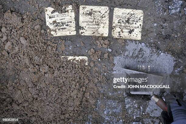 German artist Gunter Demnig lays "stolpersteine" or stumbling stones in Berlin's Friedrichstrasse March 27, 2010. The stones, topped with small brass...