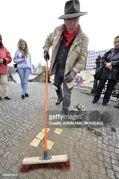 German artist Gunter Demnig cleans up after laying "stolpersteine" or stumbling stones in Berlin's Friedrichstrasse March 27, 2010. The stones,...