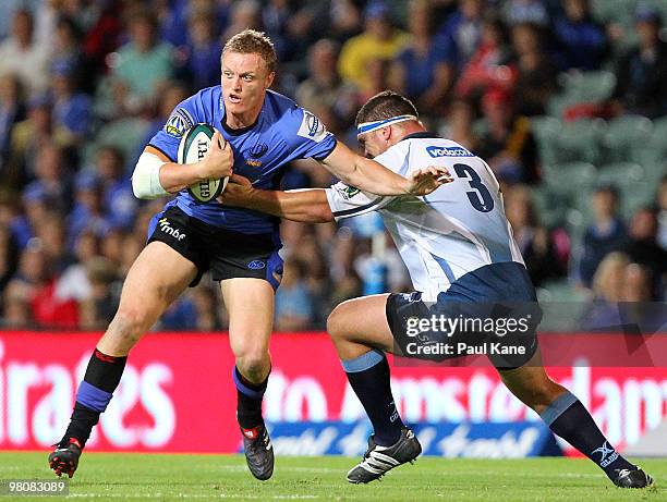 Ryan Cross of the Force attempts to break clear of a tackle by Werner Kruger of the Bulls during the round seven Super 14 match between the Western...