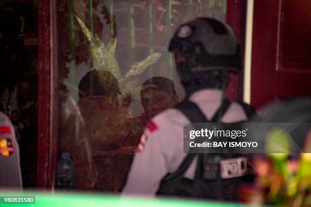 Indonesian anti-terror police officers secure the detention room before Aman Abdurrahman , who is suspected of masterminding a 2016 gun and suicide...