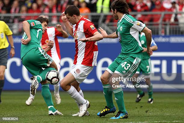 Adam Szalai of Mainz is challenged by Christian Gentner and Andrea Barzagli of Wolfsburg during the Bundesliga match between FSV Mainz 05 and VfL...