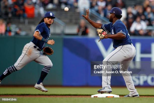 Freddy Galvis of the San Diego Padres tosses the ball to Jose Pirela of the San Diego Padres to turn a double play against the San Francisco Giants...