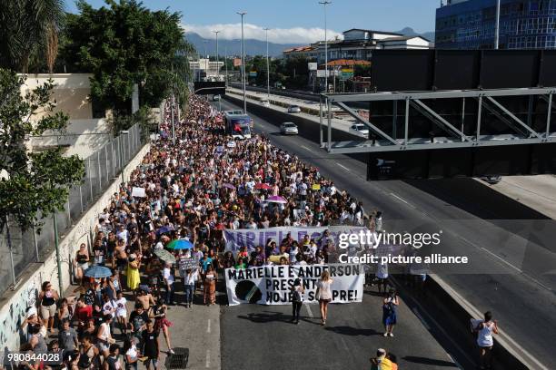 People take part in a demonstration in remembrance of Brazilian politician Marielle Franco who was assassinated on Wednesday, in Rio de Janeiro,...