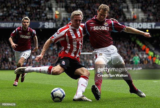 Liam Lawrence of Stoke attempts to cross the ball as Jonathan Spector of West Ham closes in during the Barclays Premier League match between West Ham...