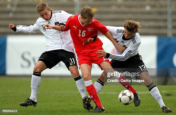 Florian Hartherz and Sonny Kittel of Germany fight for the ball with Joel Geissmann of Switzerland during the U17 Euro Qualifier match between...
