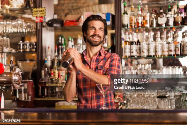 bartender with cocktail shaker - cocktail shaker stock pictures, royalty-free photos & images