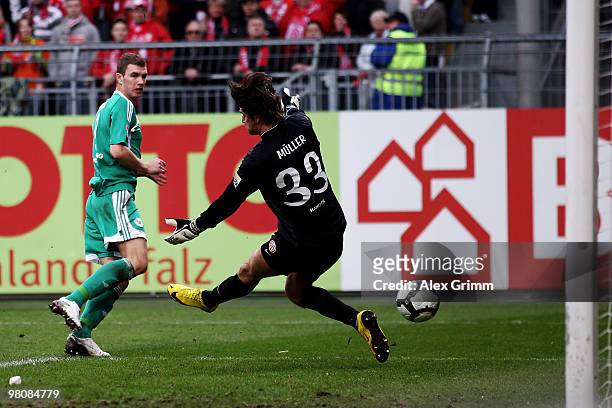 Edin Dzeko of Wolfsburg scores his team's first goal against goalkeeper Heinz Mueller of Mainz during the Bundesliga match between FSV Mainz 05 and...
