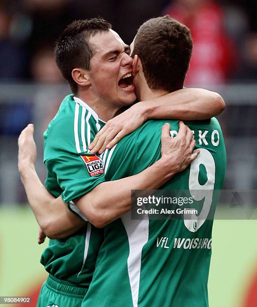 Edin Dzeko of Wolfsburg celebrates after scoring his team's first goal with team mate Marcel Schaefer during the Bundesliga match between FSV Mainz...