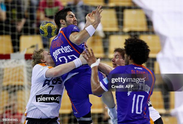 Montpellier's French Nikola Karabatic is stopped by KIF Kolding's Danish Anders Oechsler and Rene Toft Hansen during their Champions League the last...