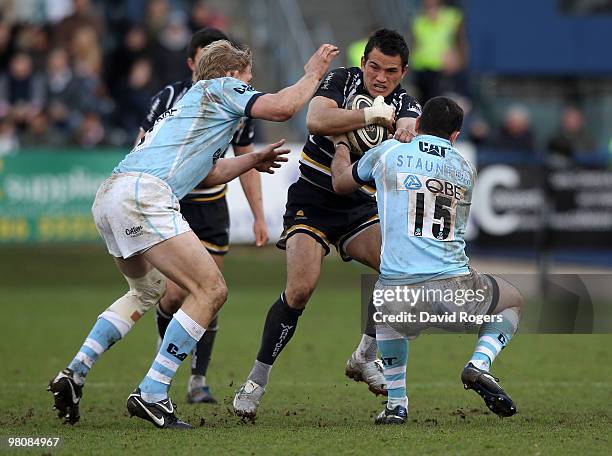 Willie Walker of Worcester is tackled by Jeremy Staunton and Lewis Moody during the Guinness Premiership match between Worcester Warriors and...