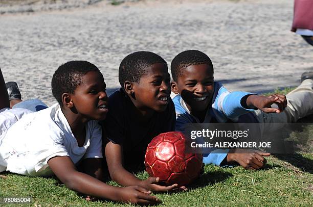 Boys watch a football match in the Gugulethu township outside of Cape Town on December 2, 2009. With the draw for the World Cup 2010 turning Cape...