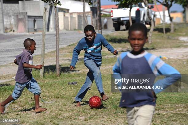 Boys play football in the Gugulethu township outside of Cape Town on December 2, 2009. With the draw for the World Cup 2010 turning Cape Town into a...