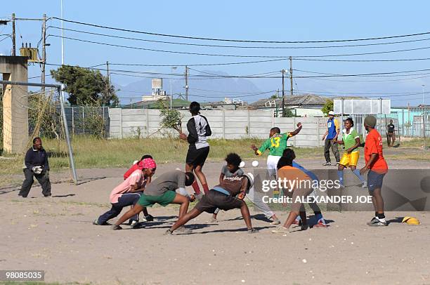 Girls stretch before playing football in the Gugulethu township outside of Cape Town on December 2, 2009. With the draw for the World Cup 2010...