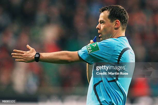 Referee Markus Schmidt makes a point during the Bundesliga match between Werder Bremen and 1. FC Nuernberg at the Weser Stadium on March 27, 2010 in...