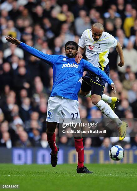 Younes Kaboul of Tottenham Hotspur is challenged by Nwankwo Kanu of Portsmouth during the Barclays Premier League match between Tottenham Hotspur and...