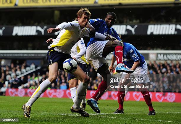Peter Crouch of Tottenham Hotspur is challenged by Aaron Mokoena of Portsmouth during the Barclays Premier League match between Tottenham Hotspur and...