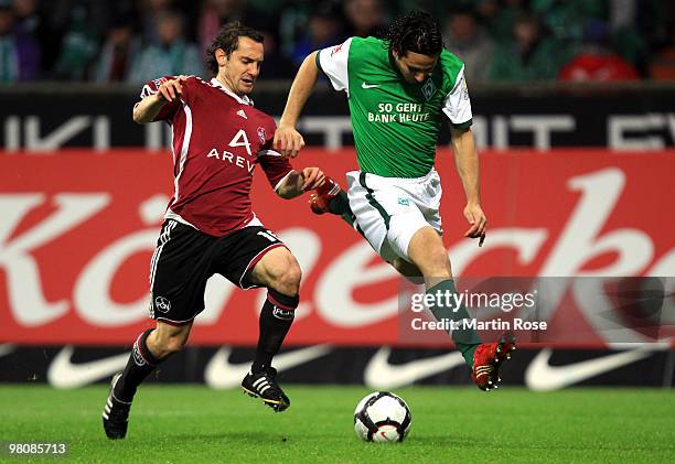 Claudio Pizarro of Bremen and Dominic Maroh of Nuernberg compete for the ball during the Bundesliga match between Werder Bremen and 1. FC Nuernberg...