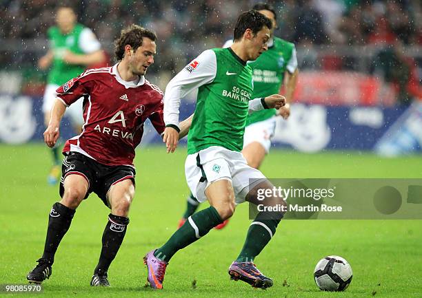 Mesut Oezil of Bremen and Juri Judt of Nuernberg compete for the ball during the Bundesliga match between Werder Bremen and 1. FC Nuernberg at the...