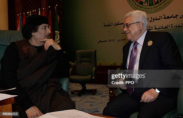 In this handout image supplied by the Palestinian Press Office , Palestinian President Mahmoud Abbas talks to Libyan leader Muammar Gaddafi on the...