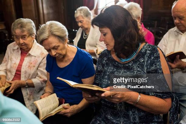 senior femenino encuentra página en himnario a unirse en el canto - libro de himnos fotografías e imágenes de stock