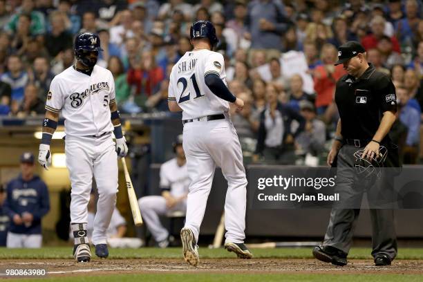 Travis Shaw of the Milwaukee Brewers scores a run on a wild pitch next to teammate Jonathan Villar in the third inning against the St. Louis...