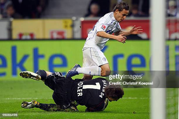 Rafinha of Schalke challenges goalkeeper Rene Adler of Leverkusen during the Bundesliga match between Bayer Leverkusen and FC Schalke 04 at the...