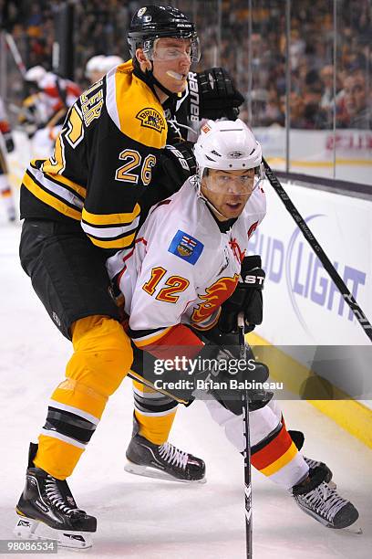 Blake Wheeler of the Boston Bruins checks Jarome Iginla of the Calgary Flames at the TD Garden on March 27, 2010 in Boston, Massachusetts.