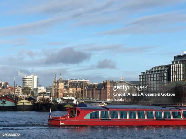 amsterdam canals and central station at background - barge stock pictures, royalty-free photos & images