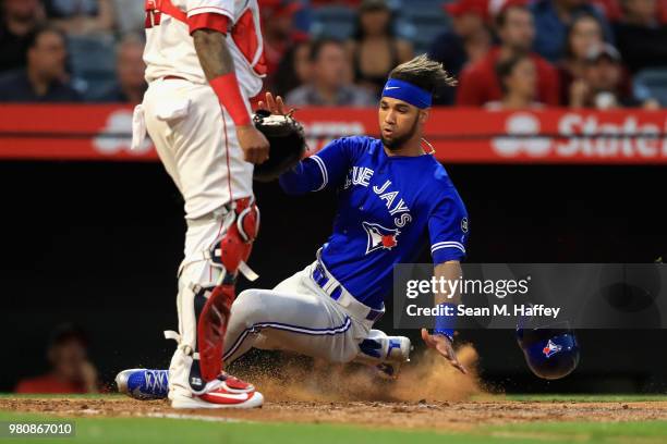 Lourdes Gurriel Jr. #13 slides safely at home, scoring on a double by Justin Smoak of the Toronto Blue Jays during the third inning of a game against...