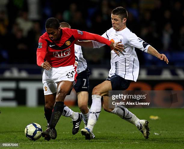 Gary Cahill of Bolton Wanderers challenges Antonio Valencia of Manchester United during the Barclays Premier League match between Bolton Wanderers...