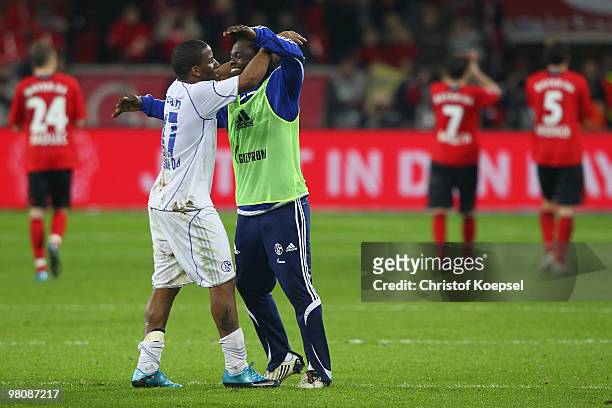 Jefferson Farfan and Gerald Asamoah of Schalke celebrate the 2:0 victory and Leverkusen looks dejected after the Bundesliga match between Bayer...