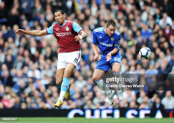 John Terry of Chelsea wins a header against John Carew of Aston Villa during the Barclays Premier League match between Chelsea and Aston Villa at...