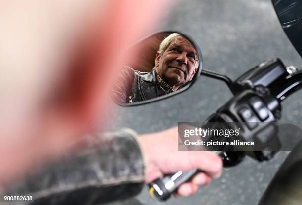 March 2018, Germany, Tuttlingen: Singer Matthias Reim sits on his new Harley Davidson motorbike and looks in the rear mirror. His new album 'Meteor'...