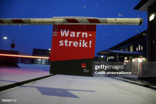 March 2018, Germany, Dortmund: A sign reads "Warnstreik" hanging from a barrier at the DSW21 bus depot. Verdi is begining a first large wave of...