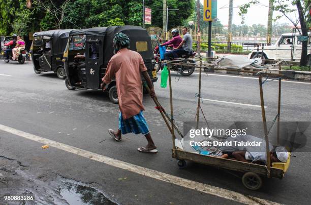 indian man pulling his handicapped son - david talukdar stockfoto's en -beelden