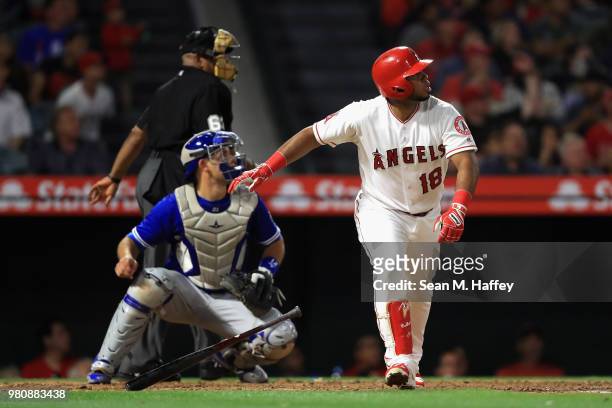 Luis Valbuena of the Los Angeles Angels of Anaheim watches his two-run homerun as Luke Maile of the Toronto Blue Jays and umpire Laz Diaz look on...