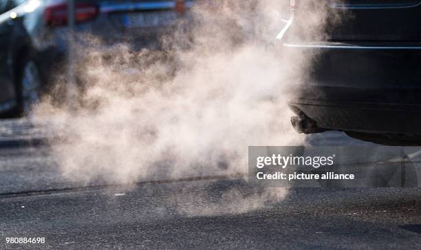 March 2018, Germany, Stuttgart: Exhaust fumes coming from the exhaust pipe of a car. The threshold values of 50 micro grams of fine dust per cubic...