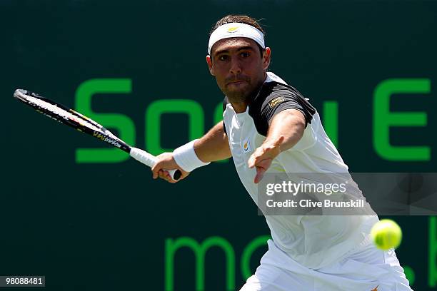 Marcos Baghdatis of Cyprus returns a shot against Juan Ignacio Chela of Argentina during day five of the 2010 Sony Ericsson Open at Crandon Park...