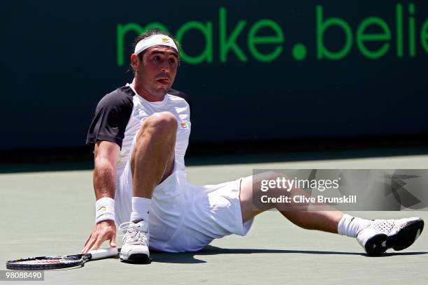 Marcos Baghdatis of Cyprus falls down while playing against Juan Ignacio Chela of Argentina during day five of the 2010 Sony Ericsson Open at Crandon...