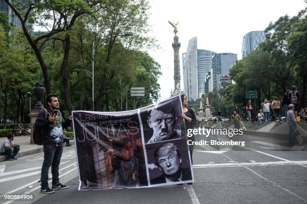 Protesters hold a banner depicting Adolf Hitler and U.S. President Donald Trump during a 'Families Belong Together' rally outside the U.S. Embassy in...