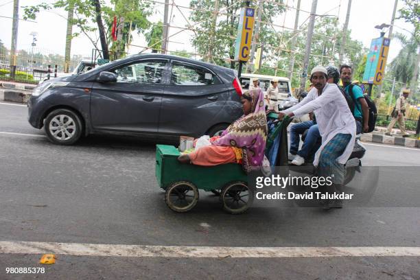 indian man pulling his handicapped son - david talukdar stockfoto's en -beelden