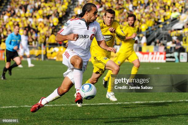 Forward Dwayne De Rosario of the Toronto FC dribbles the ball past defenseman Eric Brunner of the Columbus Crew on March 27, 2010 at Crew Stadium in...