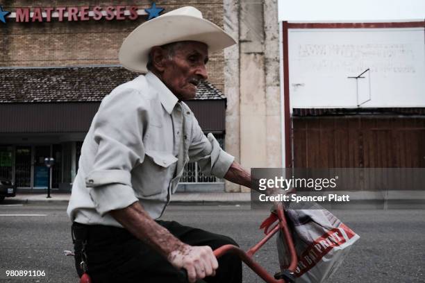 Man rides his bike past shuttered stores in downtown Brownsville, a border city which has become dependent on the daily crossing into and out of...