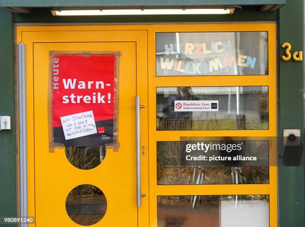 March 2018, Germany, Dortmund: "Warning strike" can be read on a poster on the door of a day care centre. The Verdi union is begining a first large...