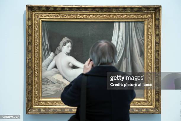 March 2018, Germany, Duesseldorf: A visitor takes a photo of the picture "Odaliske in Grisaille" by Jean-Auguste-Do Ingres from 1824-1834. The...