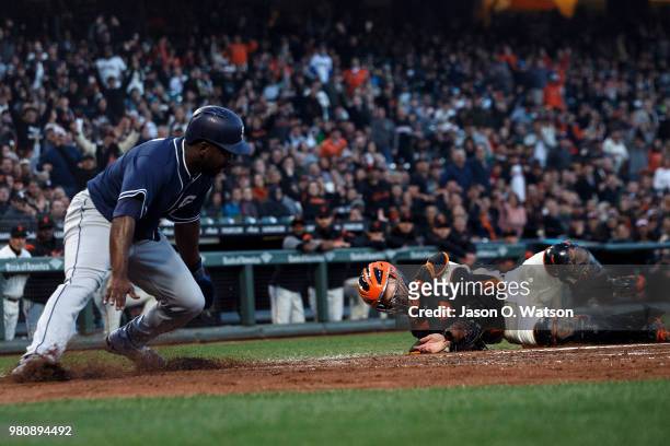 Jose Pirela of the San Diego Padres is tagged out at home plate by Buster Posey of the San Francisco Giants during the fifth inning at AT&T Park on...