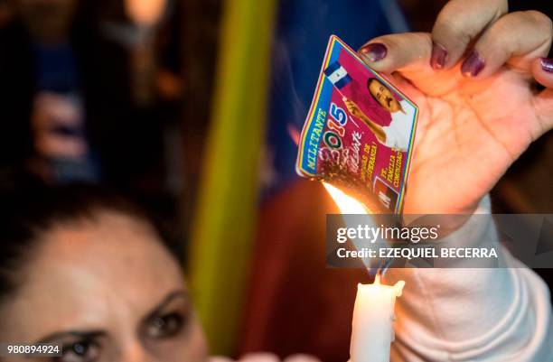 Nicaraguan woman living in Costa Rica burns her identification card of the Sandinista National Liberation Front during a demonstration against the...