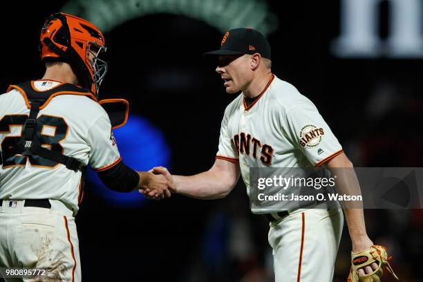 Buster Posey of the San Francisco Giants celebrates with Mark Melancon after the game against the San Diego Padres at AT&T Park on June 21, 2018 in...