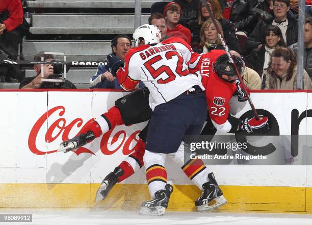 Jason Garrison of the Florida Panthers bodychecks Chris Kelly of the Ottawa Senators into the boards at Scotiabank Place on March 27, 2010 in Ottawa,...